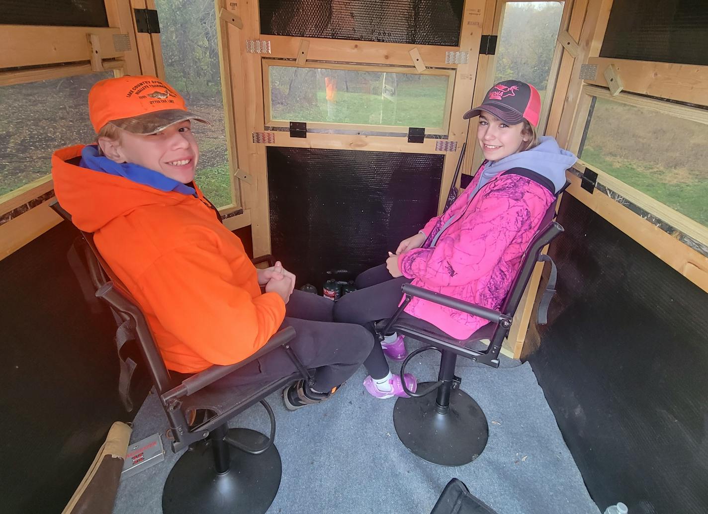 Elly Stortroen, right, 12, of Fergus Falls, Minn., is a fan of blaze pink while deer hunting, while her cousin, Alex Pederson, 15, prefers traditional blaze orange.