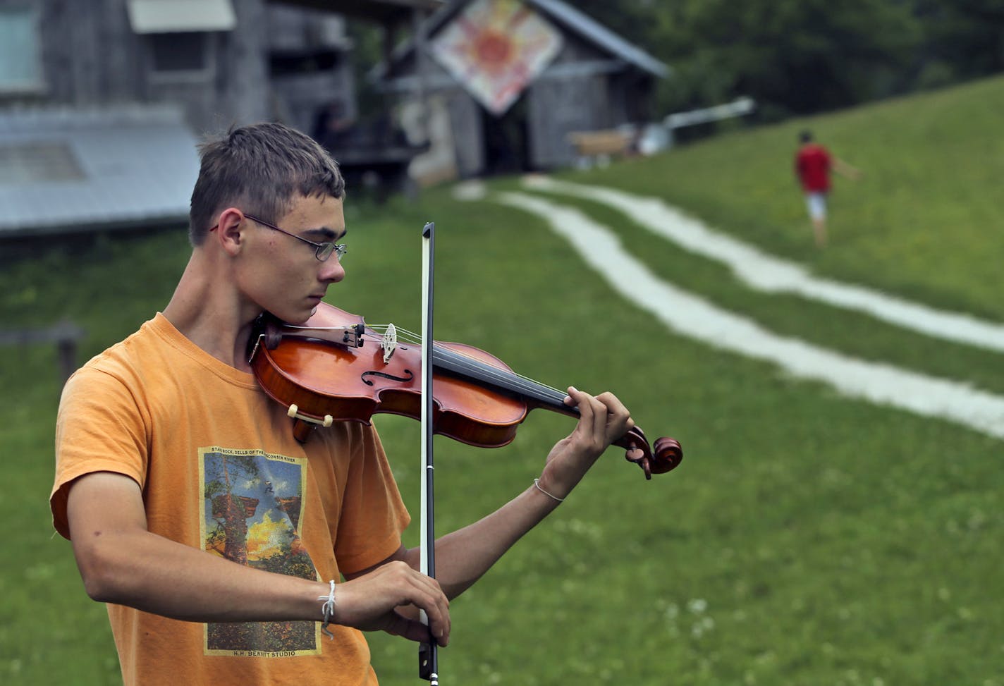 Flourish Summer Camp is a performing arts program for youth ages 11-15, located at the Dreamery Rural Arts Initiative in Wykoff, MN. The camp consists of a group of artists that mentor young people in the disciplines of theatre, puppetry, dance, music and voice for one week in the context of a farm. Here, Shawn Bagley, 16, of Nicollet, who has been to the camp five times, practices his violin in a field near the farm's garden Thursday, August 8, 2013, in Wykoff, MN. Thursday, August 8, 2013](DAV