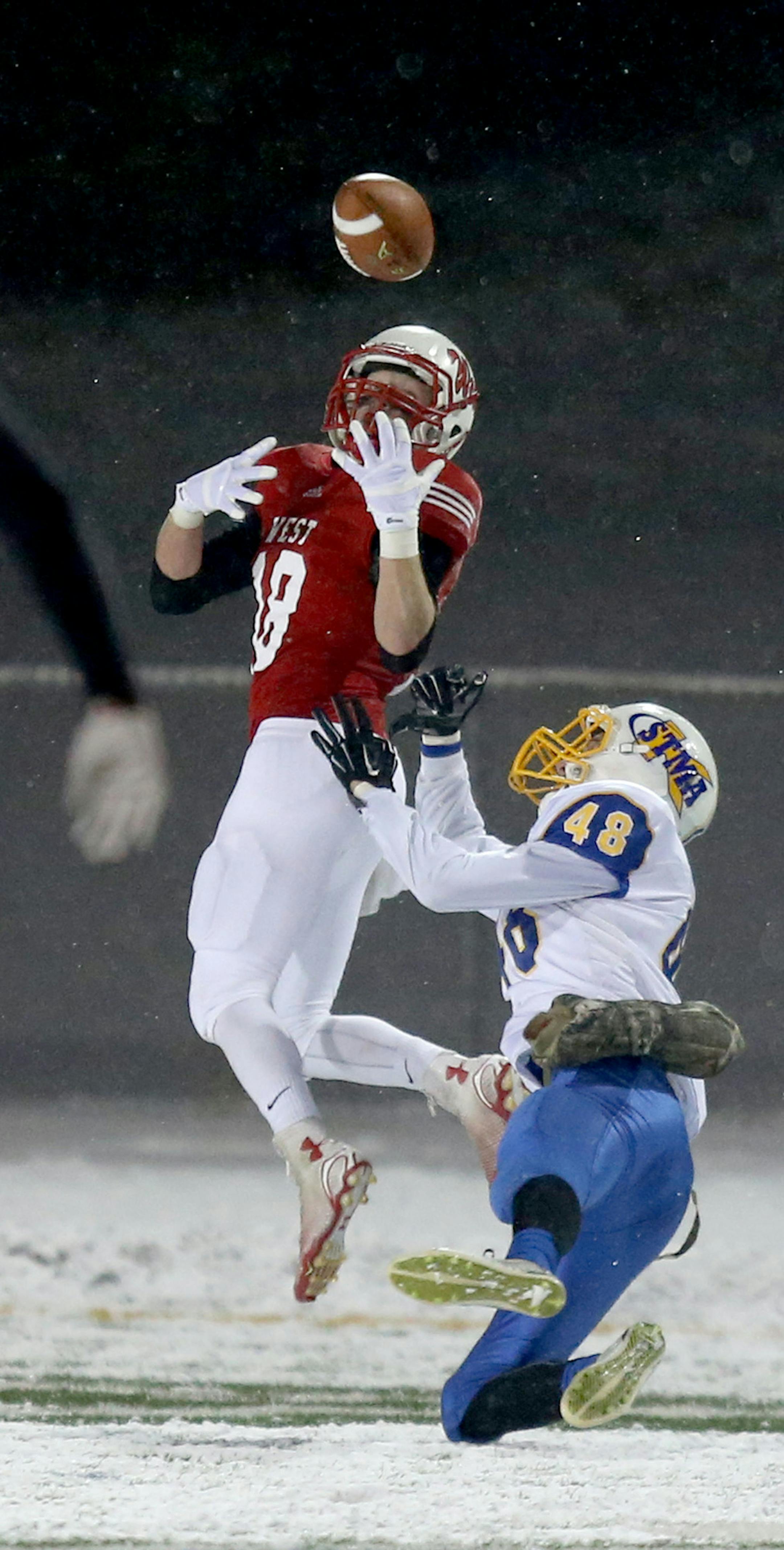 Mankato West's Connor Watts reached back for a pass with St. Michael-Albertville's Jacob Moran defending. ] (KYNDELL HARKNESS/STAR TRIBUNE) kyndell.harkness@startribune.com St. Michael-Albertville vs Mankato West in state semifinals in Eden Prairie , Min., Saturday, November 15, 2014. Mankato West won 26-21 over St. Michael-Albertville