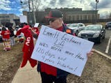 Crow Bellecourt, 51, holds a sign at a protest over the criminal neglect of Indigenous activist Emmett Eastman Sr., outside the Scott County jail on W