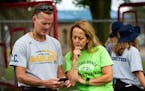 Yvette Woell look over attendance with specialty kicker coach Bill Seifert at a Totino-Grace High School football practice at Totino-Grace High School