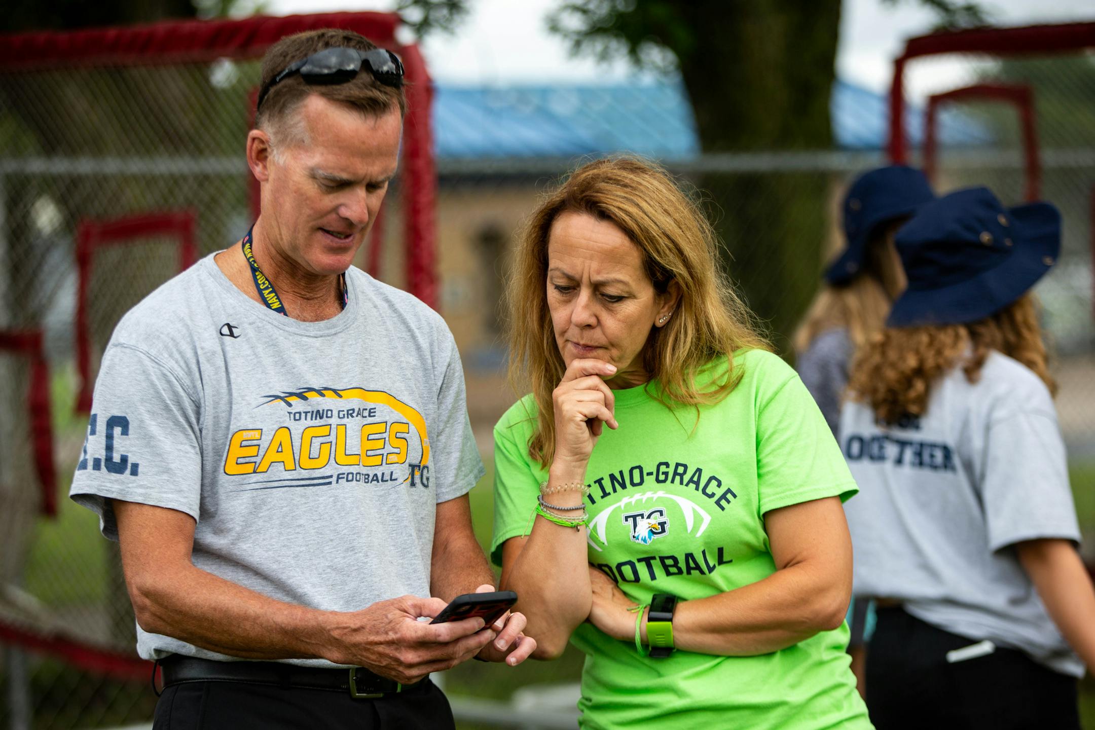 Yvette Woell look over attendance with specialty kicker coach Bill Seifert at a Totino-Grace High School football practice at Totino-Grace High School in Fridley Friday, August 16, 2019. ] NICOLE NERI • nicole.neri@startribune.com BACKGROUND INFORMATION: Yvette Woell's daughter and the Totino-Grace High School football team's senior student manager Rachel Woell died of brain cancer in her senior year in 2014. Yvette Woell now comes to every game and practice, helping the coaches and team