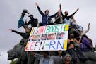 A protester holds an anti-far right banner showing the faces of French Presidents and the word 'Honte' or 'Shame' during a rally in Paris, Saturday, J