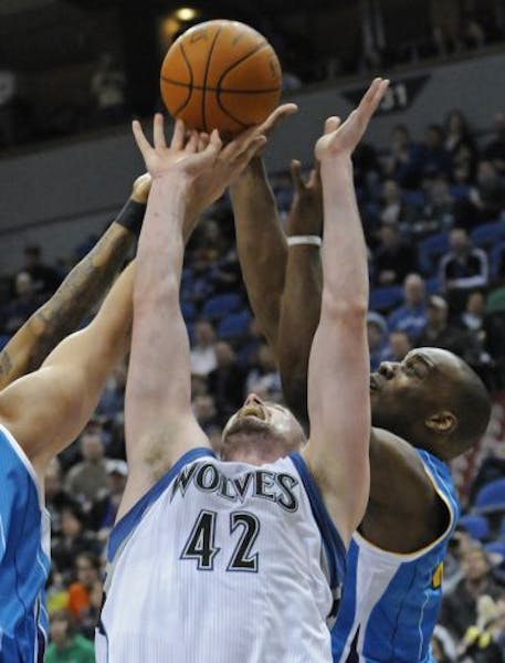 Minnesota Timberwolves' Kevin Love (42) and new New Orleans Hornets player Carl Landry, right, battle for the rebound during the first half of an NBA 