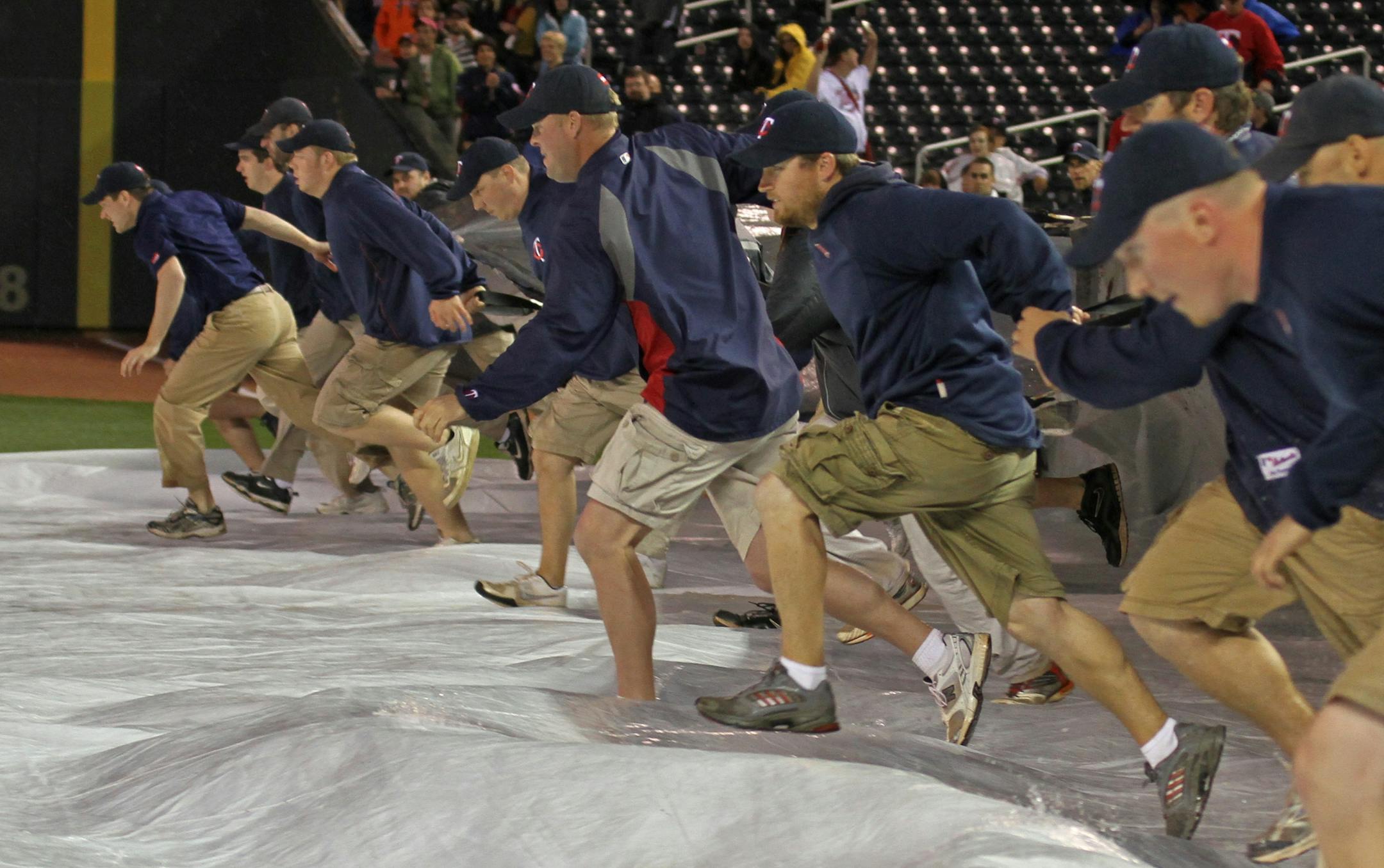 Minnesota Twins vs. Toronto Blue Jays, 5/11/12, Target Field. (left to right) Twins grounds crew pulled the tarp to drain the water, as the game was delayed by rain. Bruce Bisping/Star Tribune bbisping@startribune.com