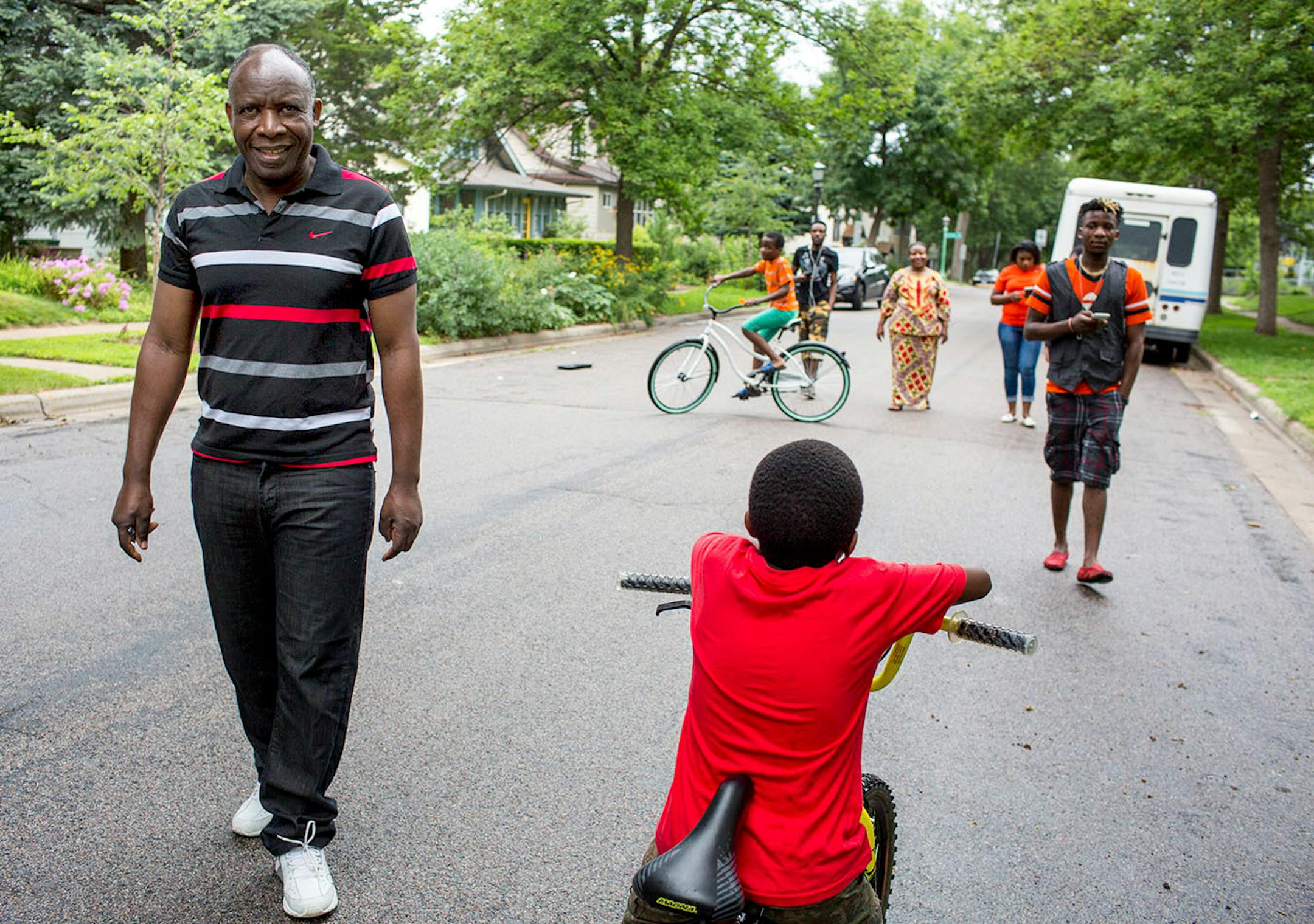 Ladislas Mihigo (left) looks ahead during a family walk around the block near their St. Paul home, on Sunday afternoon.
