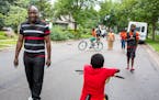 Ladislas Mihigo (left) looks ahead during a family walk around the block near their St. Paul home, on Sunday afternoon.
