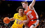 Minnesota guard Sean Sutherlin (24) tries to move around Illinois guard Luke Goode (10) during the first half of an NCAA college basketball game Tuesd