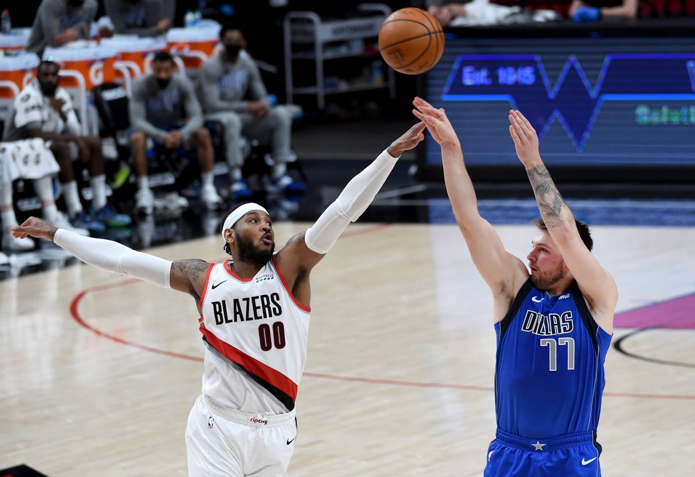 Dallas Mavericks guard Luka Doncic, right, hits a shot over Portland Trail Blazers forward Carmelo Anthony during the second half of an NBA basketball game in Portland, Ore., Friday, March 19, 2021. The Blazers won 125-119. AP Photo/Steve Dykes)