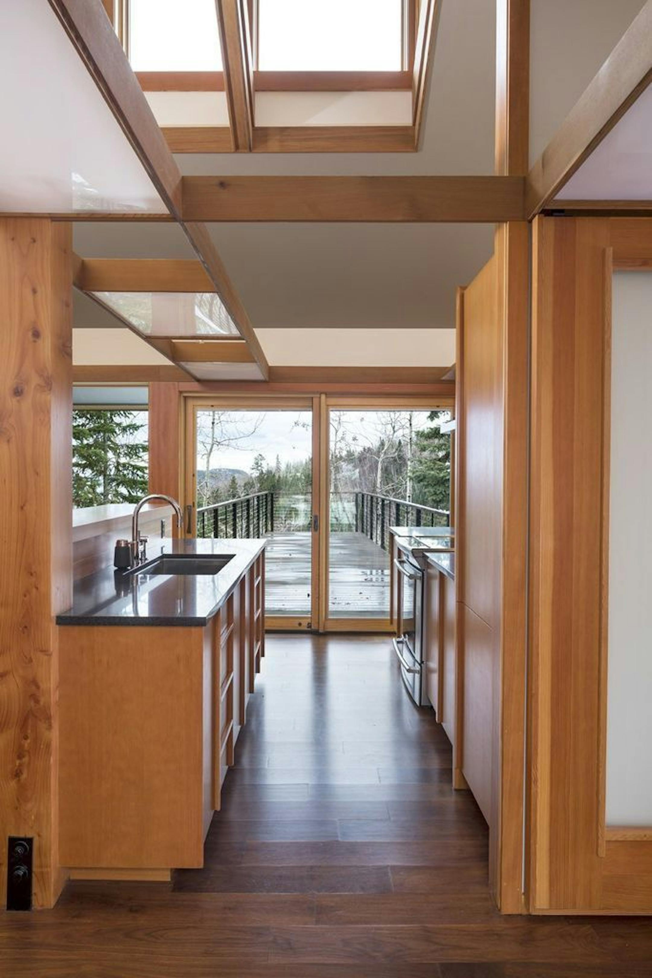 The front entry view connects to the wooded landscape on the lake side.