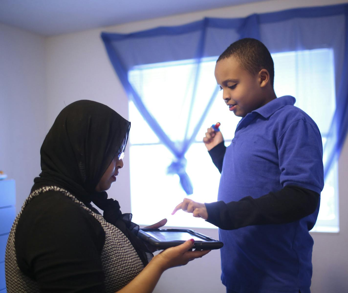 A University of Minnesota study released Monday, December 16, 2013, has found elevated rates of Autism among children who are white or Somali in the Twin Cities when compared to black or Hispanic youngsters. With the help of an iPad, eleven year-old Abdullahi told his mom, Idil Abdull, what he'd like for a quick snack before they had to leave their home in Savage Monday afternoon, December 16, 2013 for a therapy appointment for his Autism. He's largely non-verbal but can use a program loaded on