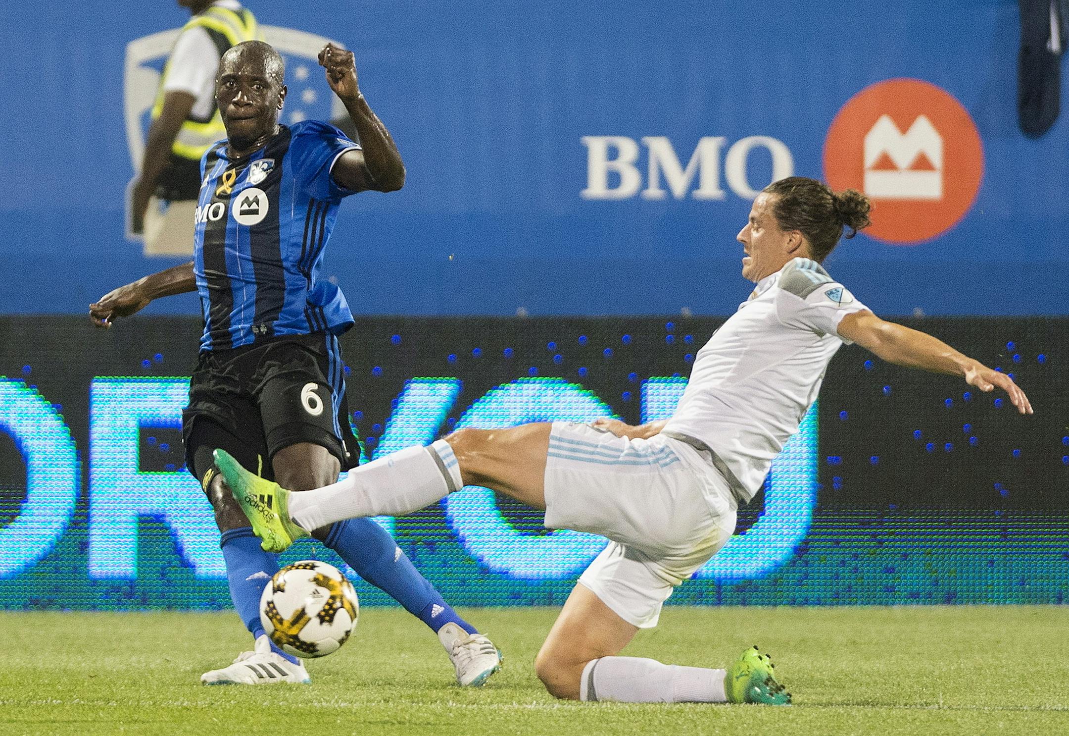 Montreal Impact's Hassoun Camara, left, challenges Minnesota United FC's Marc Burch during first half MLS soccer action in Montreal, Saturday, Sept. 16, 2017. (Graham Hughes/The Canadian Press via AP)