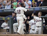 Minnesota Twins catcher Chris Herrmann (12) high fived second baseman Brian Dozier (2) after Herrmann hit a homer against the Cleveland Indians in the