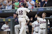 Minnesota Twins catcher Chris Herrmann (12) high fived second baseman Brian Dozier (2) after Herrmann hit a homer against the Cleveland Indians in the