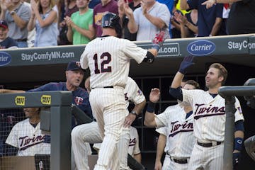 Minnesota Twins catcher Chris Herrmann (12) high fived second baseman Brian Dozier (2) after Herrmann hit a homer against the Cleveland Indians in the