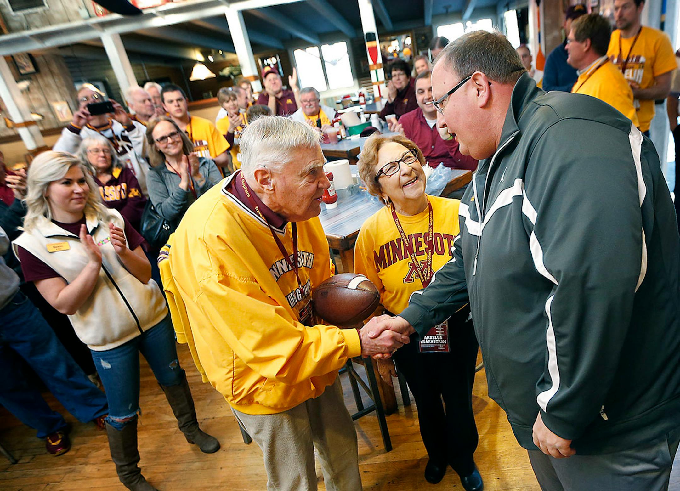 Minnesota head football coach Tracy Claeys made a surprise appearance as he presented first time bowl visitors Warren and Ardella Quarnstrom with a football during a breakfast, Tuesday, December 27, 2016 in San Diego, CA. The couple, both 91, made their first time football bowl trip from Marshall, MN.