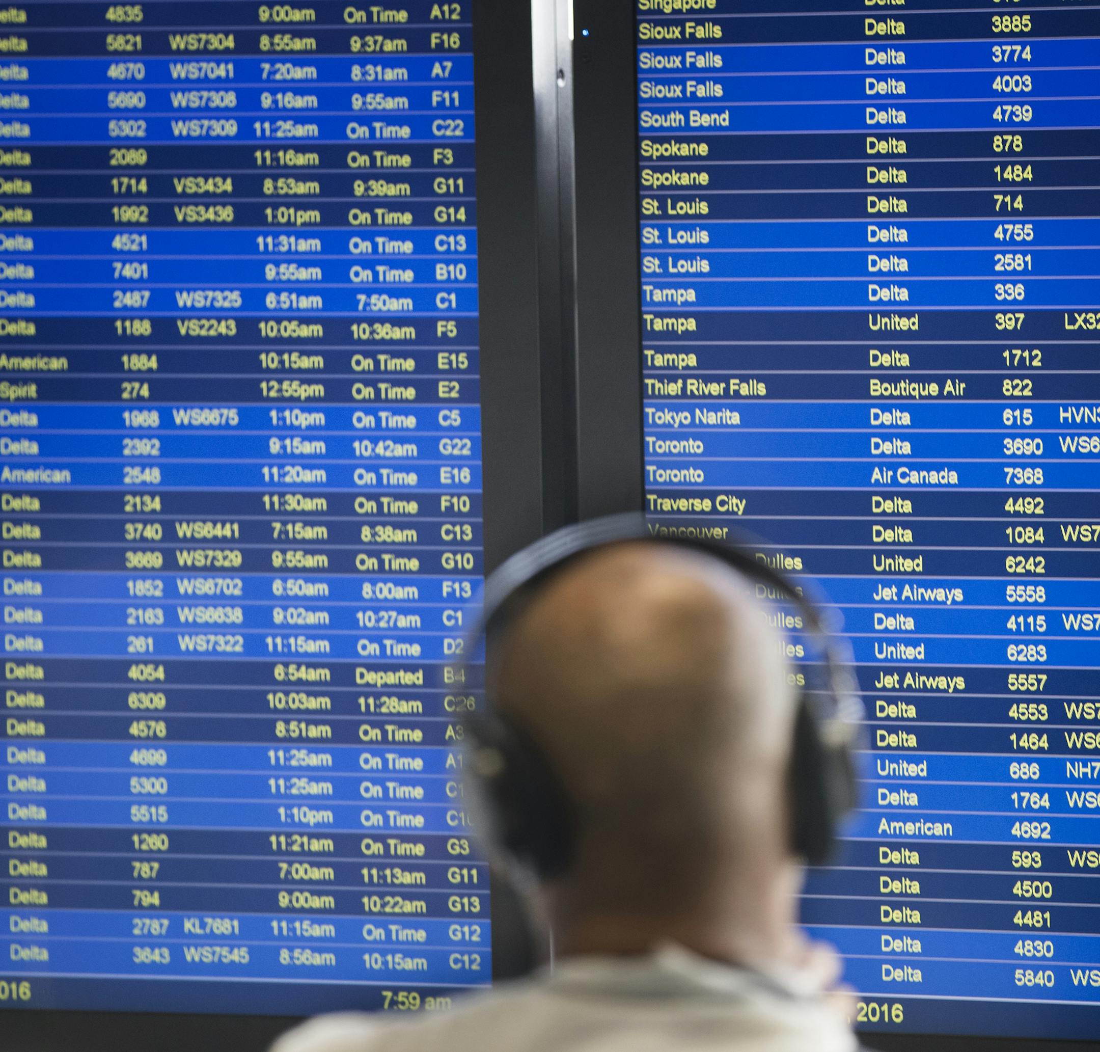 A man checks the departures and arrivals board in Terminal 1 at MSP Airport. ] (Leila Navidi/Star Tribune) leila.navidi@startribune.com BACKGROUND INFORMATION: At Minneapolis - St. Paul International Airport on Monday, August 8, 2016. A power outage in Atlanta, which began at approximately 2:30 AM EST impacted Delta computer systems and operations worldwide, resulting in massive flight delays and cancellations.