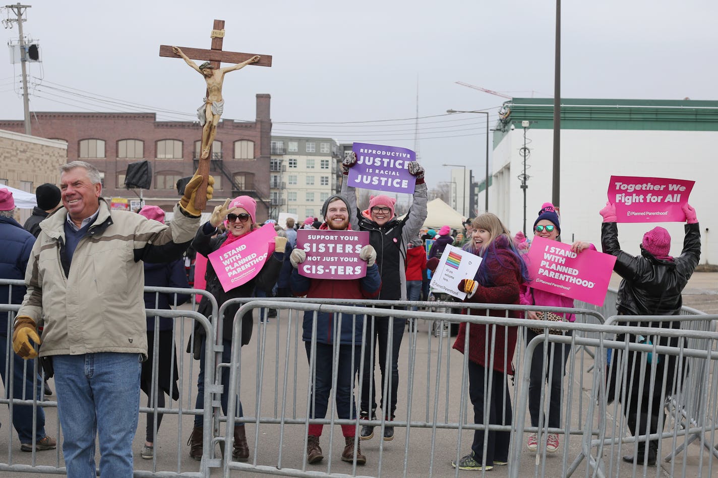 Tom Keuhn holds a cross during a Good Friday demonstration outside Planned Parenthood as pro-choice advocates flaunt their signs on the other side of the fence at Planned Parenthood's Solidarity Day on Friday in St. Paul.