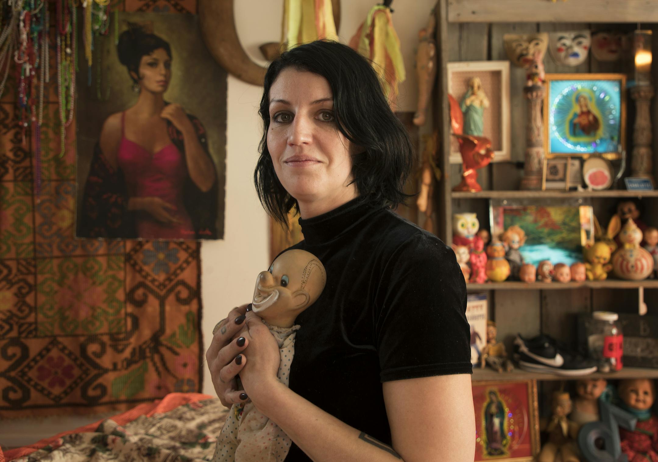 Charlotte Strait decorates her Minneapolis apartment with vintage collectibles including her childhood clown, a wall of Halloween masks, toys and other offbeat articles.