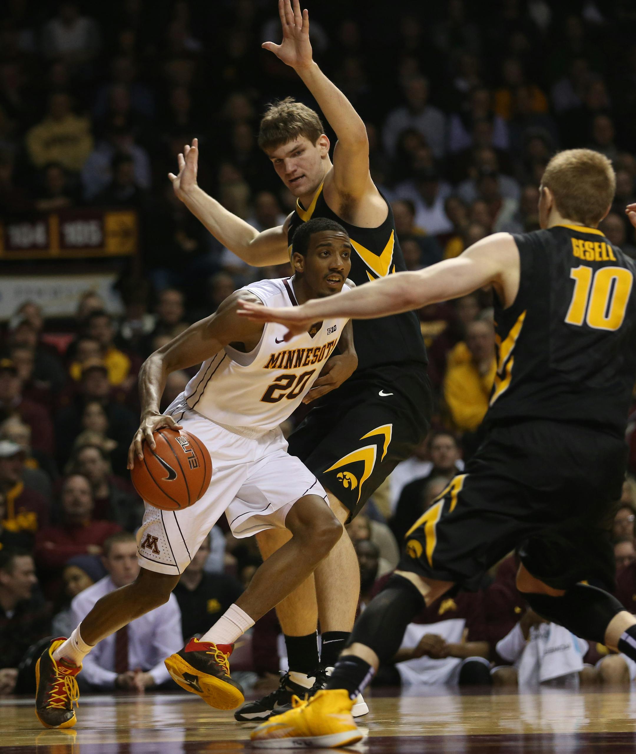 Gopher Austin Hollins drove to the basket passed Iowa's Adam Woodbury during the second half at Williams Arena Tuesday, February 25, 2014. Gophers won over Iowa 95-89. ] (KYNDELL HARKNESS/STAR TRIBUNE) kyndell.harkness@startribune.com