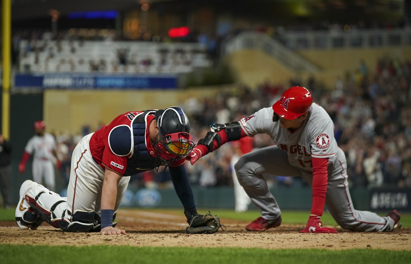 Los Angeles Angels designated hitter Shohei Ohtani reached to check on Twins catcher Mitch Garver after he was thrown out at home when he tried to score from second base when the Angels' Brian Goodwin singled to center in the eighth inning. Garver was injured on the play.