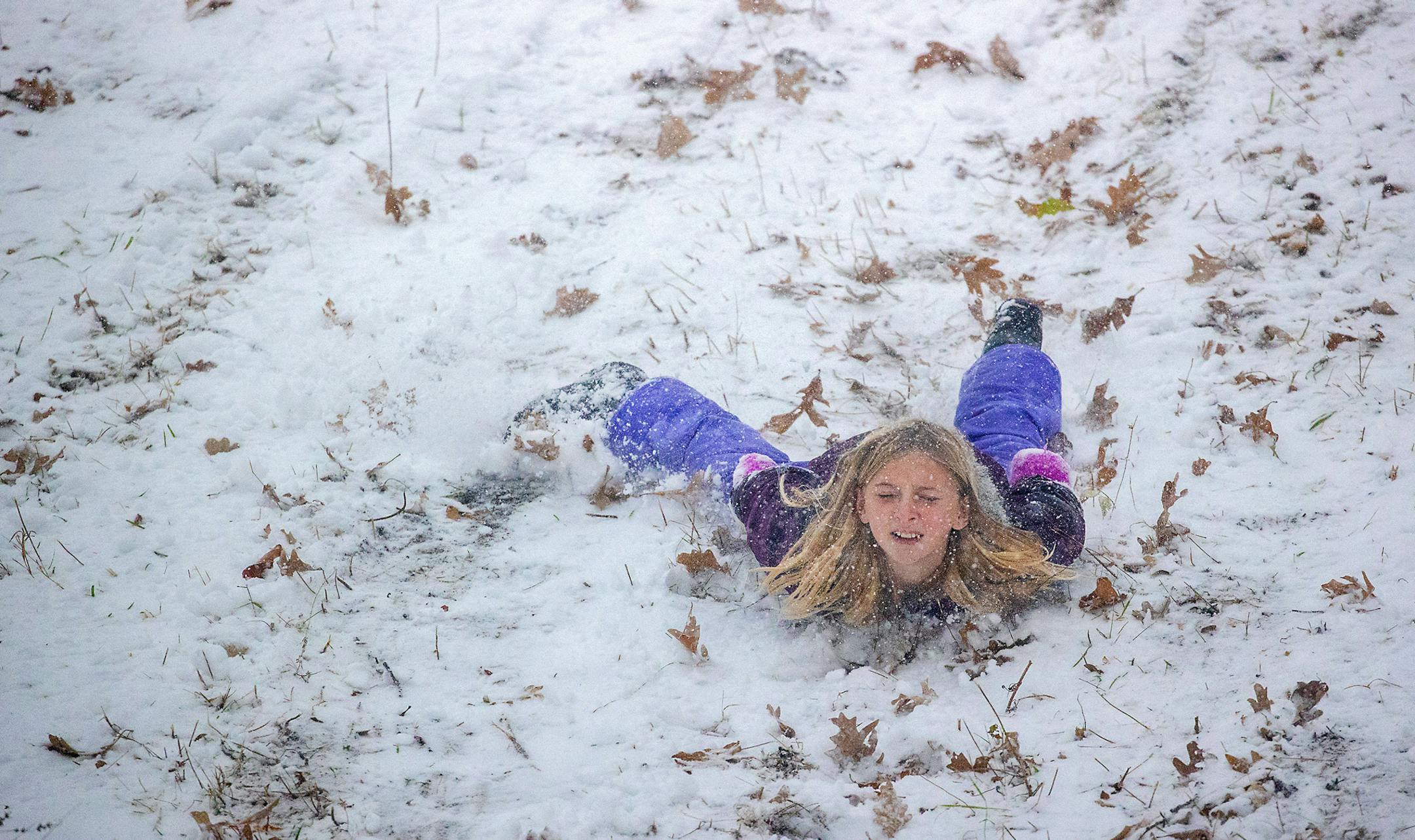 Lula Humphries, 11, skipped the sled and slid on her tummy down a hill near Lake Nokomis in Minneapolis. ] ELIZABETH FLORES • liz.flores@startribune.com