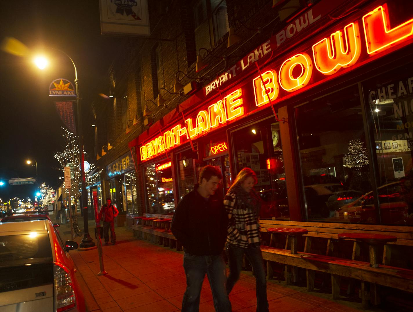 The Bryant-Lake Bowl sign casts a neon glow onto the sidewalk and passers by, Friday, November 8th, 2013. ] (Matthew Hintz, Minneapolis, 110813)