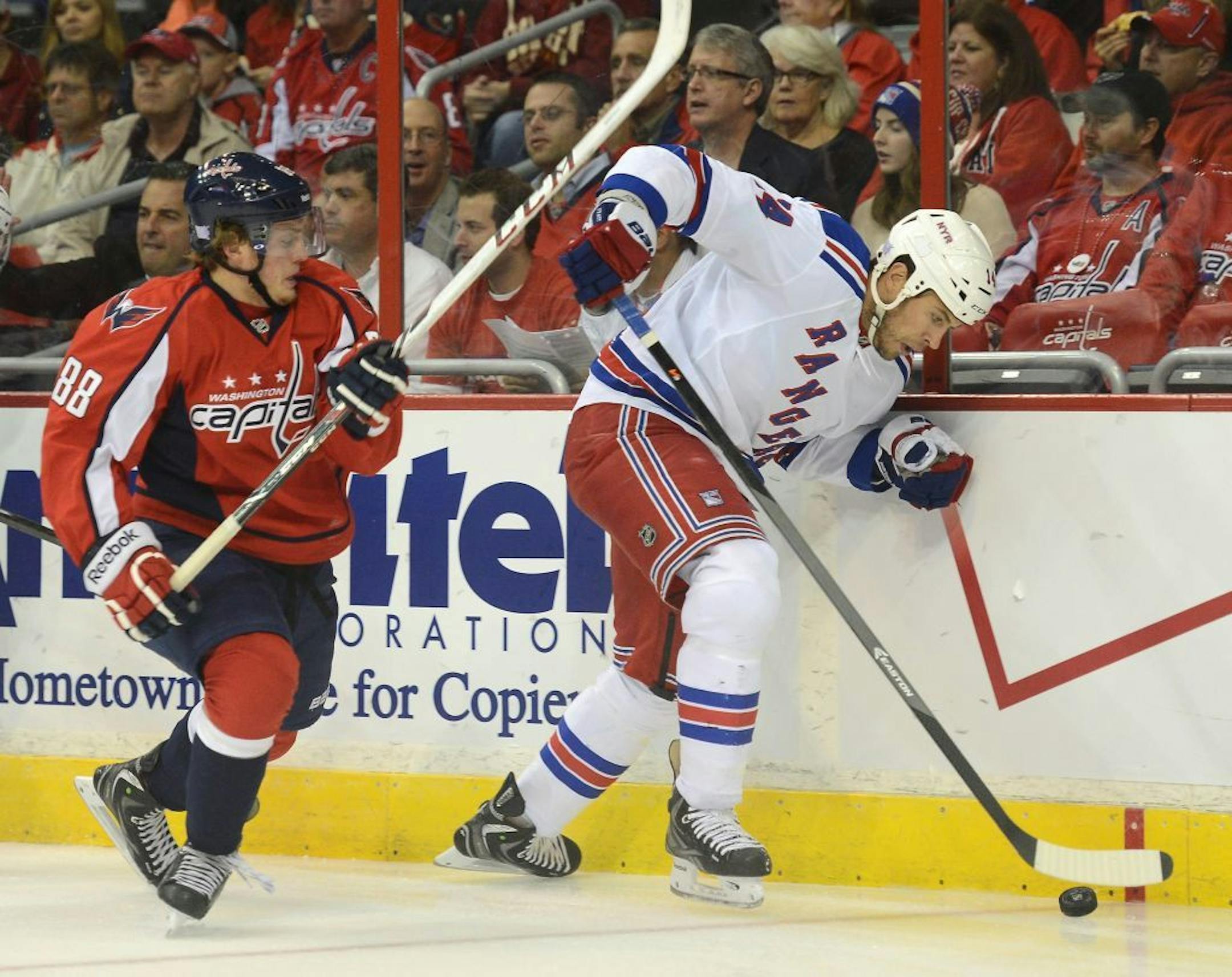 New York Rangers left wing Taylor Pyatt (14) works the puck along the boards against Washington Capitals defenseman Nate Schmidt (88) in the first period at the Verizon Center in Washington, D.C., Wednesday, October 16, 2013.