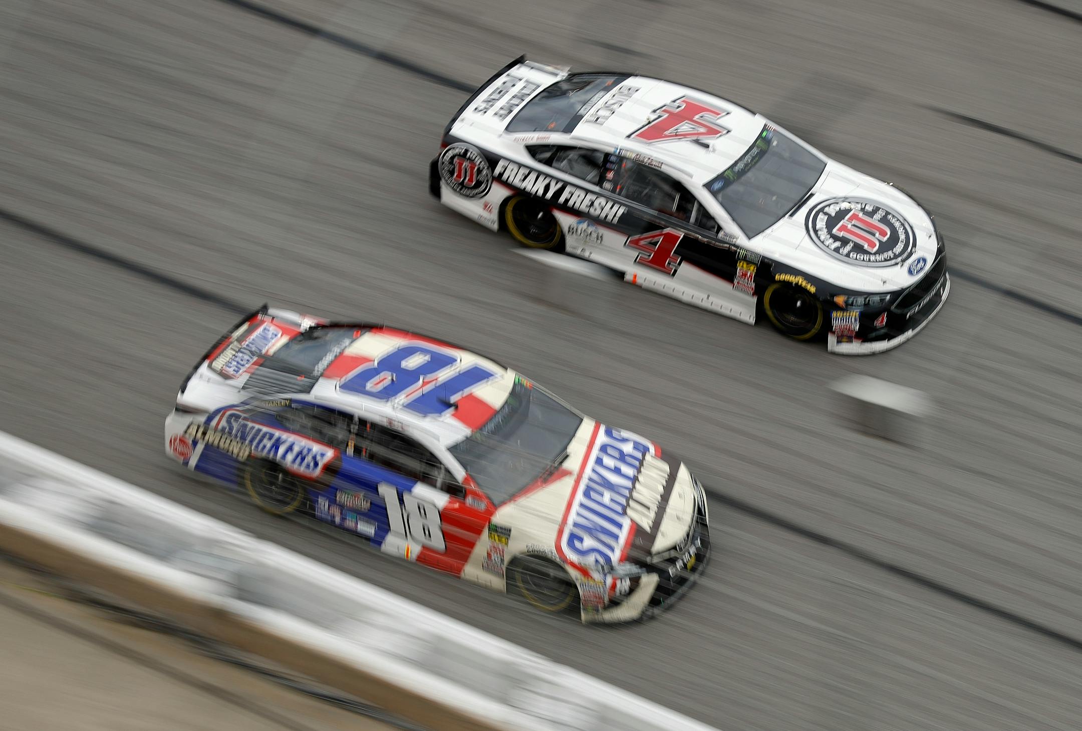 NASCAR drivers Kyle Busch (18) and eventual winner Kevin Harvick (4) raced down the front stretch during Sunday's race at Atlanta Motor Speedway in Hampton, Ga.