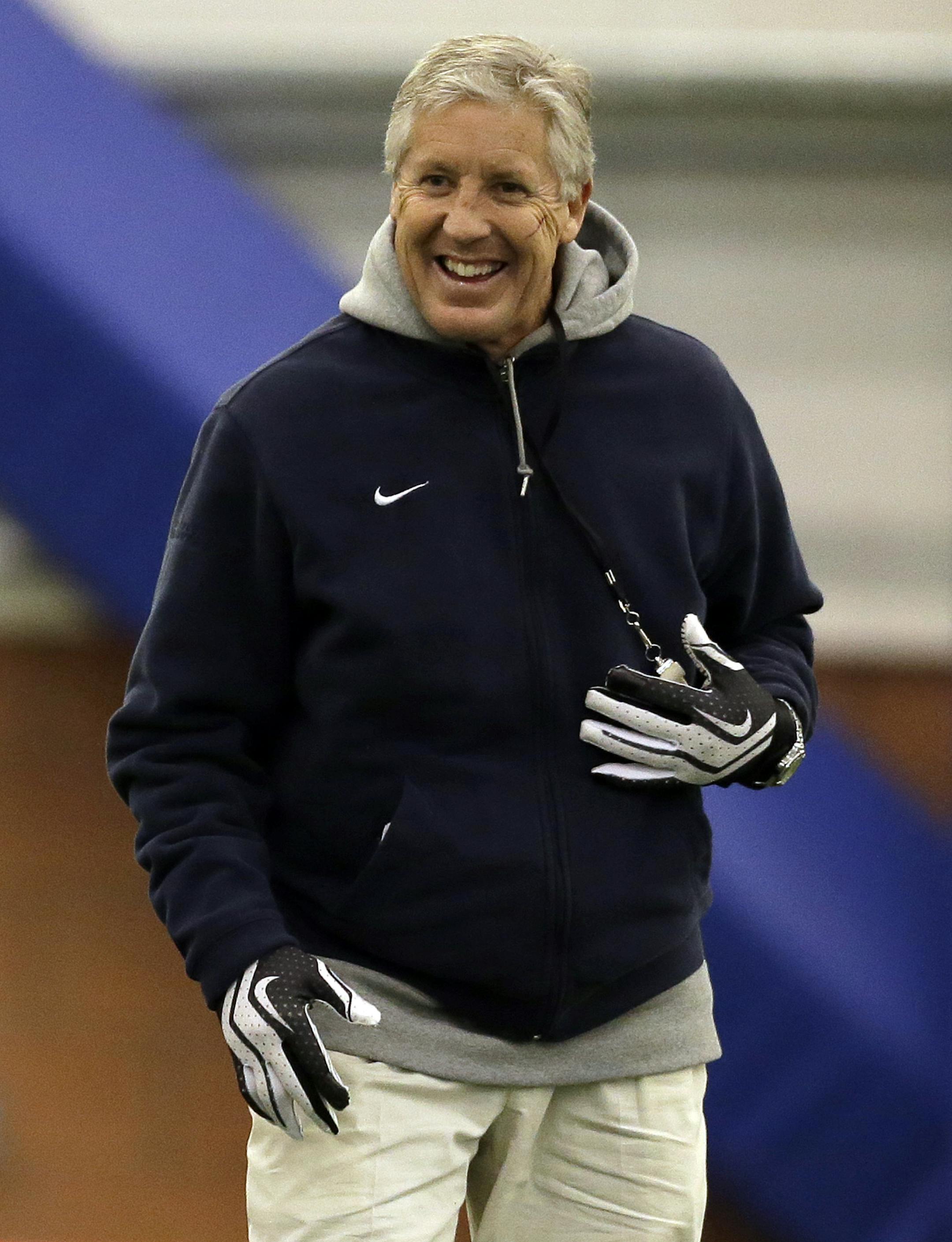 Seattle Seahawks head coach Pete Carroll smiles as his teams warms up for NFL football practice Thursday, Jan. 30, 2014, in East Rutherford, N.J. The Seahawks and the Denver Broncos are scheduled to play in the Super Bowl XLVIII football game Sunday, Feb. 2, 2014. (AP Photo)