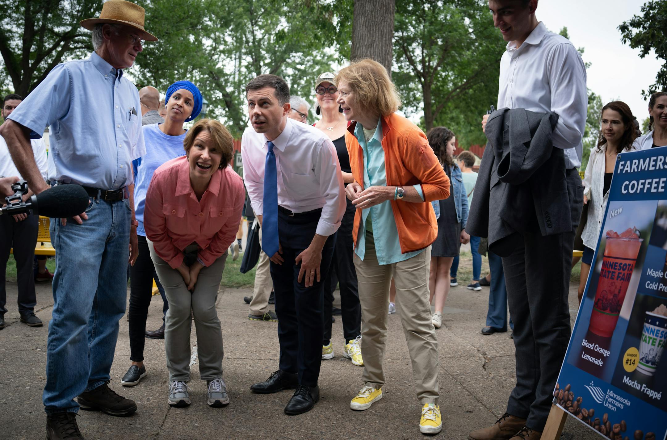 U.S. Transportation Secretary Pete Buttigieg crouched down to read the menu of the Farmers Union as he toured the Minnesota State Fair with Rep. Ilhan Omar, Sen. Amy Klobuchar and Sen. Tina Smith Thursday, Aug. 25, 2022, Falcon Heights, Minn.