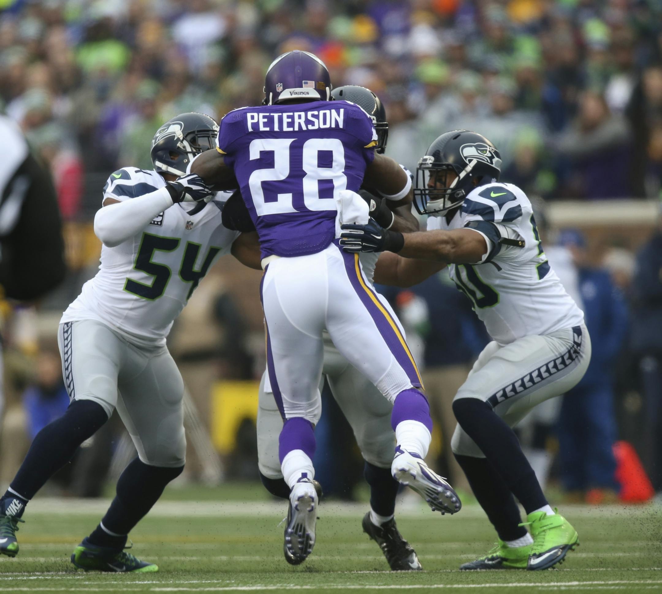 Vikings running back Adrian Peterson (28) was stopped by a wall of Seahawks as he gained four yards on a first quarter run Sunday.