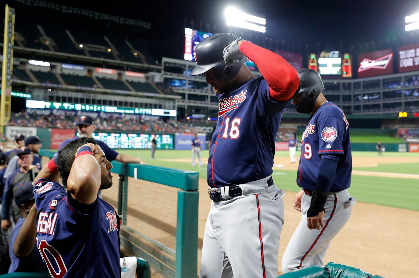 Minnesota Twins' Eddie Rosario, left, and Jonathan Schoop (16) celebrate a two-run home run by Schoop during the seventh inning of the team's baseball game against the Texas Rangers in Arlington, Texas, Friday, Aug. 16, 2019. (AP Photo/Tony Gutierrez)