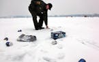 A DNR conservation officer picked up trash on a lake in Prior Lake in 2010. The littering problem has gotten worse statewide since then. Overnight gue