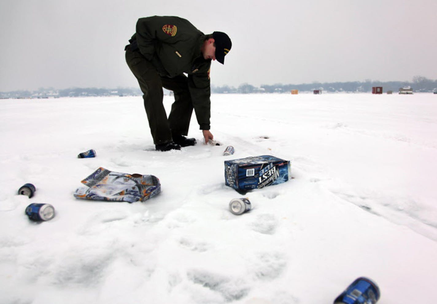 A DNR conservation officer picked up trash on a lake in Prior Lake in 2010. The littering problem has gotten worse statewide since then. Overnight guests often are the worst offenders.