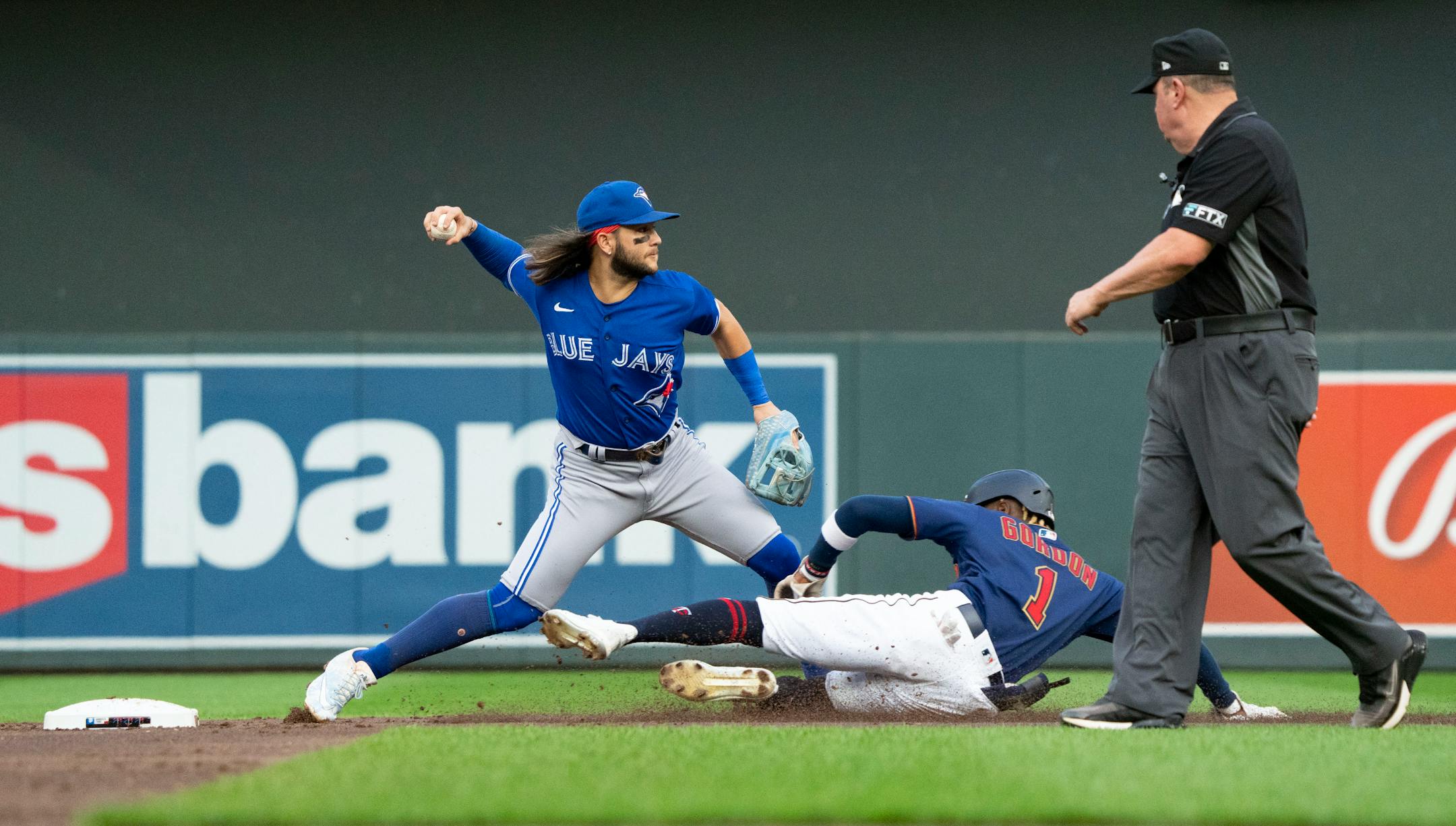 Toronto Blue Jays shortstop Bo Bichette (11) works on completing a double play as Minnesota Twins left fielder Nick Gordon (1) tries to slide into second in the second inning.