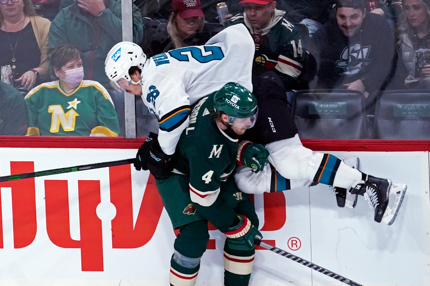 San Jose Sharks' Jasper Weatherby (26) is checked along the board by Minnesota Wild's Jon Merrill (4) during the first period of an NHL hockey game Tuesday, Nov. 16, 2021, in St. Paul, Minn. (AP Photo/Jim Mone)