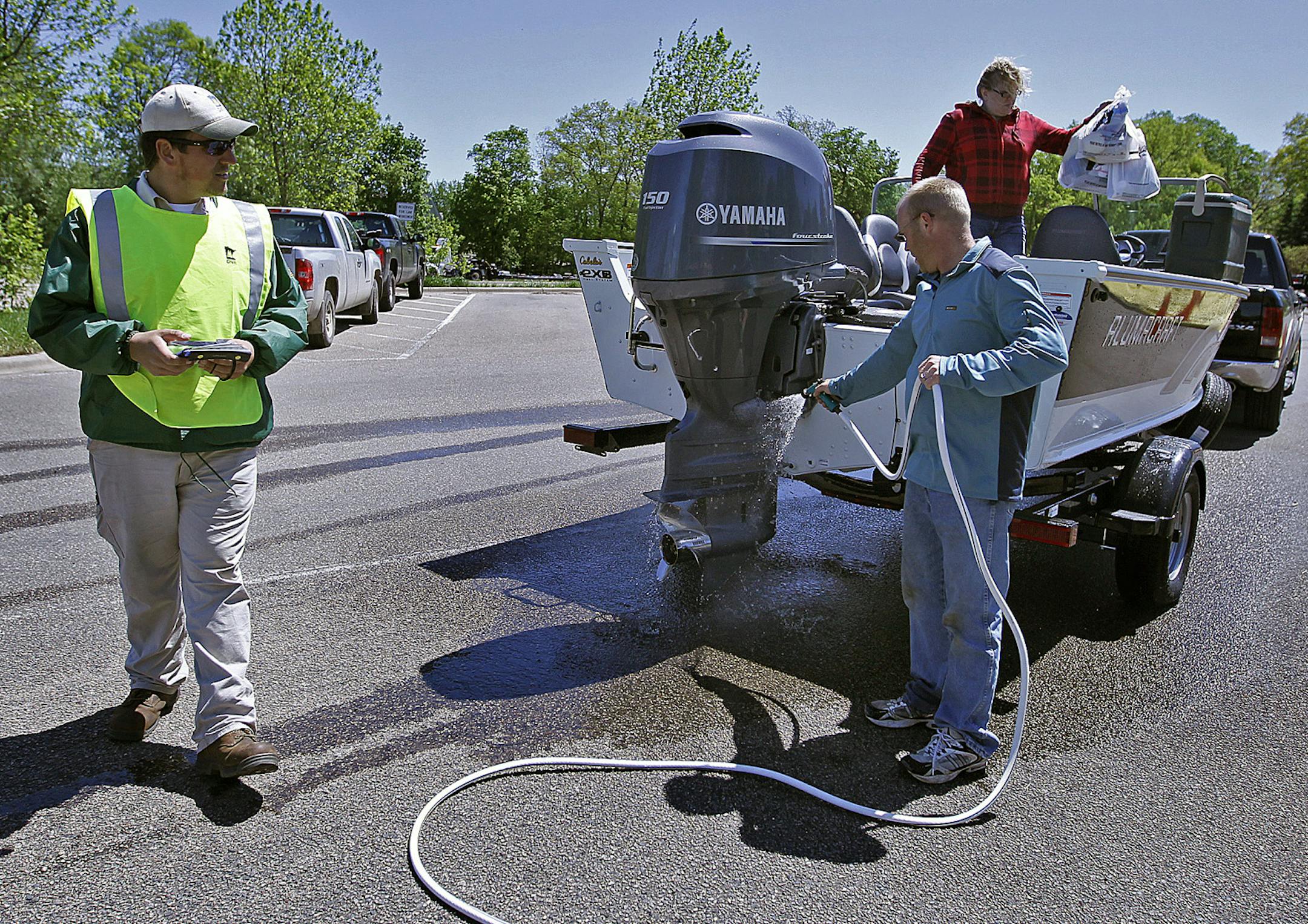 Steve Rondeau, a DNR watercraft inspector, chatted with new boat owners Anthony and Yvette Hutchins of St. Louis Park after they got out of Lake Minnetonka, Thursday, May 23, 2013. Minnesota boaters should be prepared for even more efforts this year to curb the spread of zebra mussels and other invasive species by a higher number of enforcement personnel. (ELIZABETH FLORES/STAR TRIBUNE) ELIZABETH FLORES • eflores@startribune.com