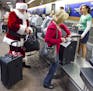 FILE - In this Wednesday, 21, 2011, file photo, holiday travelers, including Donald Occimio of Mesa, Ariz., dressed as Santa Claus, and his wife Diane