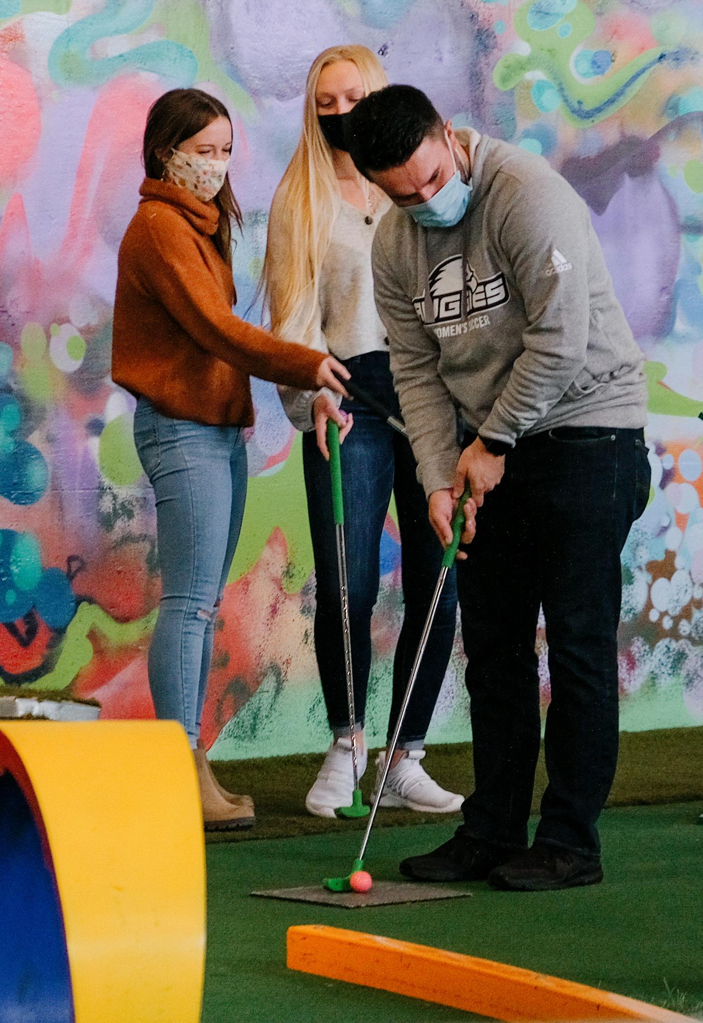 Mini golf players wear masks at Can Can Wonderland in St. Paul.