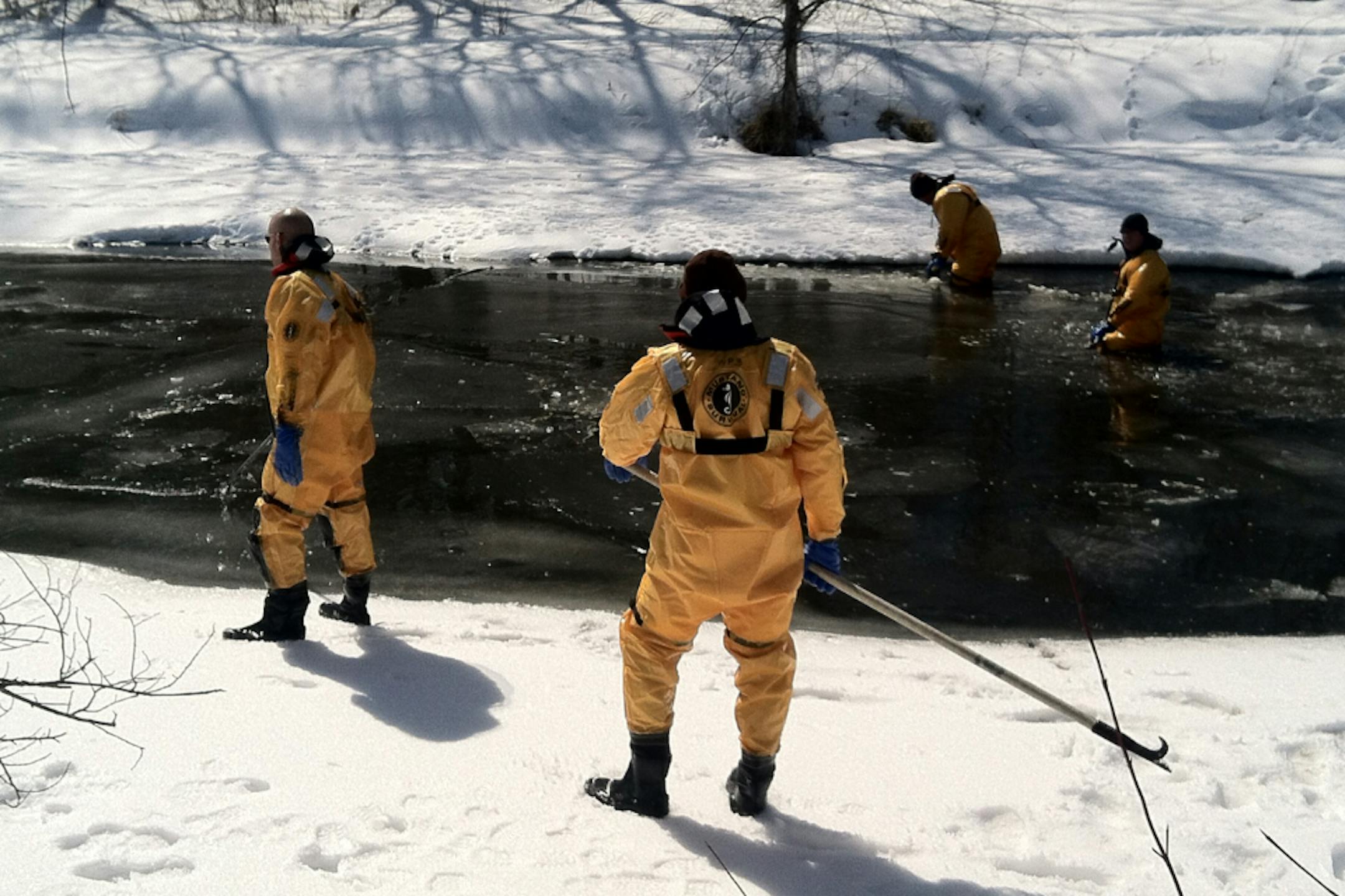 Divers with the Ramsey County Sheriffi's department search the creek near Keller Lake in Maplewood Monday after searchers turned up items of interest in the search for Kira Trevino on Sunday.