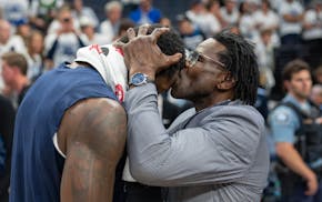 Pro Football Hall of Famer Michael Irvin kisses his good friend, Timberwolves forward Julius Randle, after the Timberwolves' victory over the Warriors