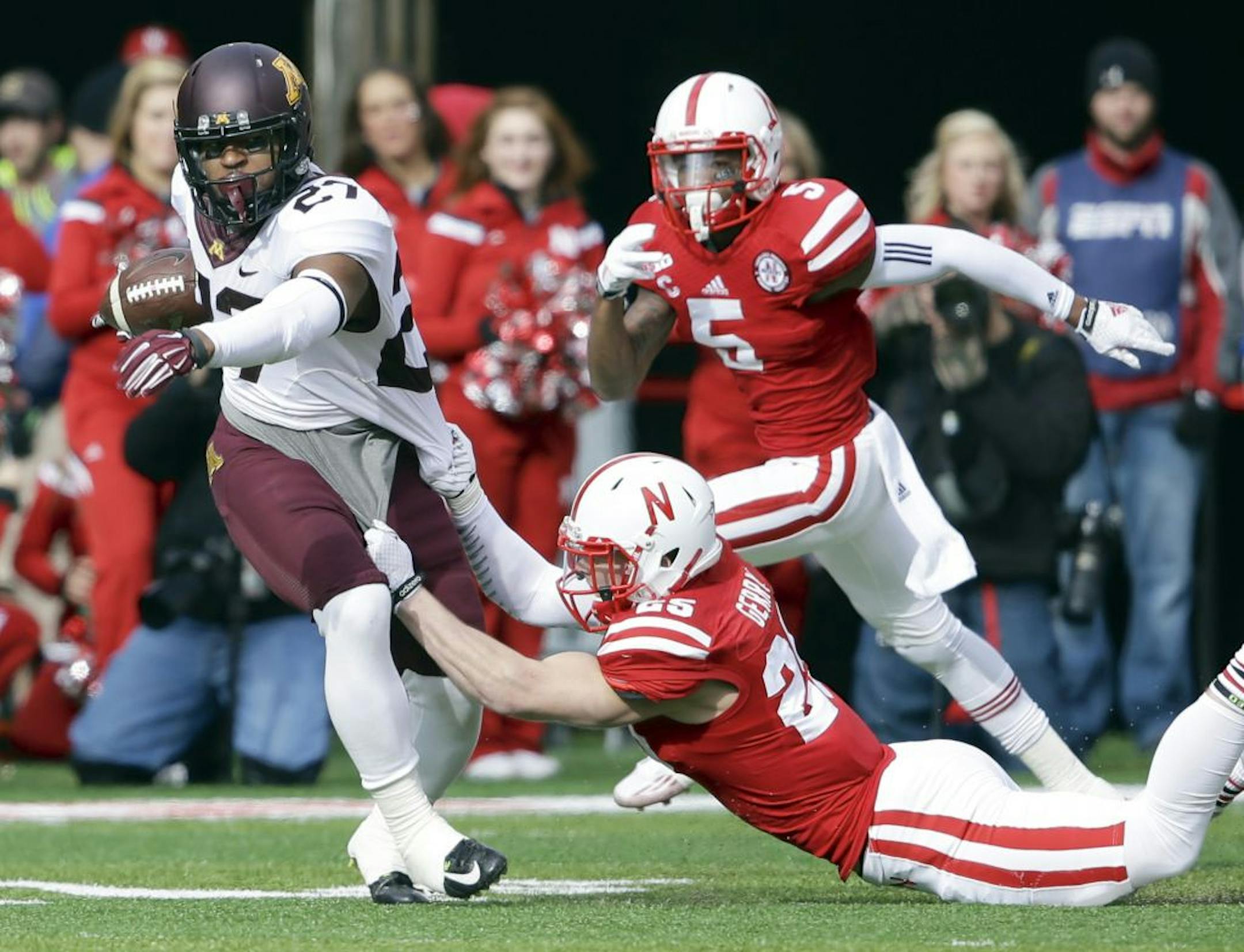 Gophers running back David Cobb was tackled by Nebraska defensive back Nate Gerry (25) as cornerback Josh Mitchell (5) moved in during the first half Saturday.