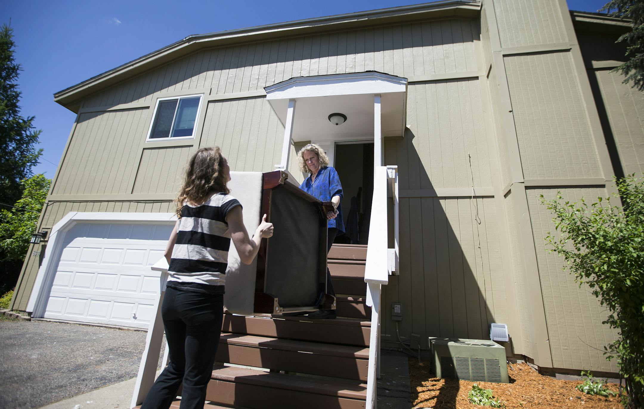 Anita Rockwell, right, and her daughter Casey Rockwell of StageWorks take furniture out of a home while staging it for sale in Lakeville. ] (Leila Navidi/Star Tribune) leila.navidi@startribune.com BACKGROUND INFORMATION: Tuesday, May 17, 2016 in Lakeville. For Twin Cities home buyers, the spring frenzy continues. With buyers outpacing sellers in many areas, prices increased nearly 8 percent, according to a monthly report released Tuesday morning by the Minneapolis Area Association. Anita Rockwel