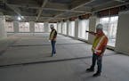 Construction manager Ron Basara, right, shows off the outline of studio apartments going in at the former Ecolab University Center in downtown St. Pau