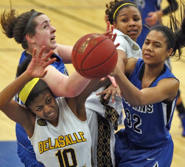 Both teams fought for control of a rebound including DeLaSalle's Joi Jones (10) and Hopkins' Nia Coffey (32).