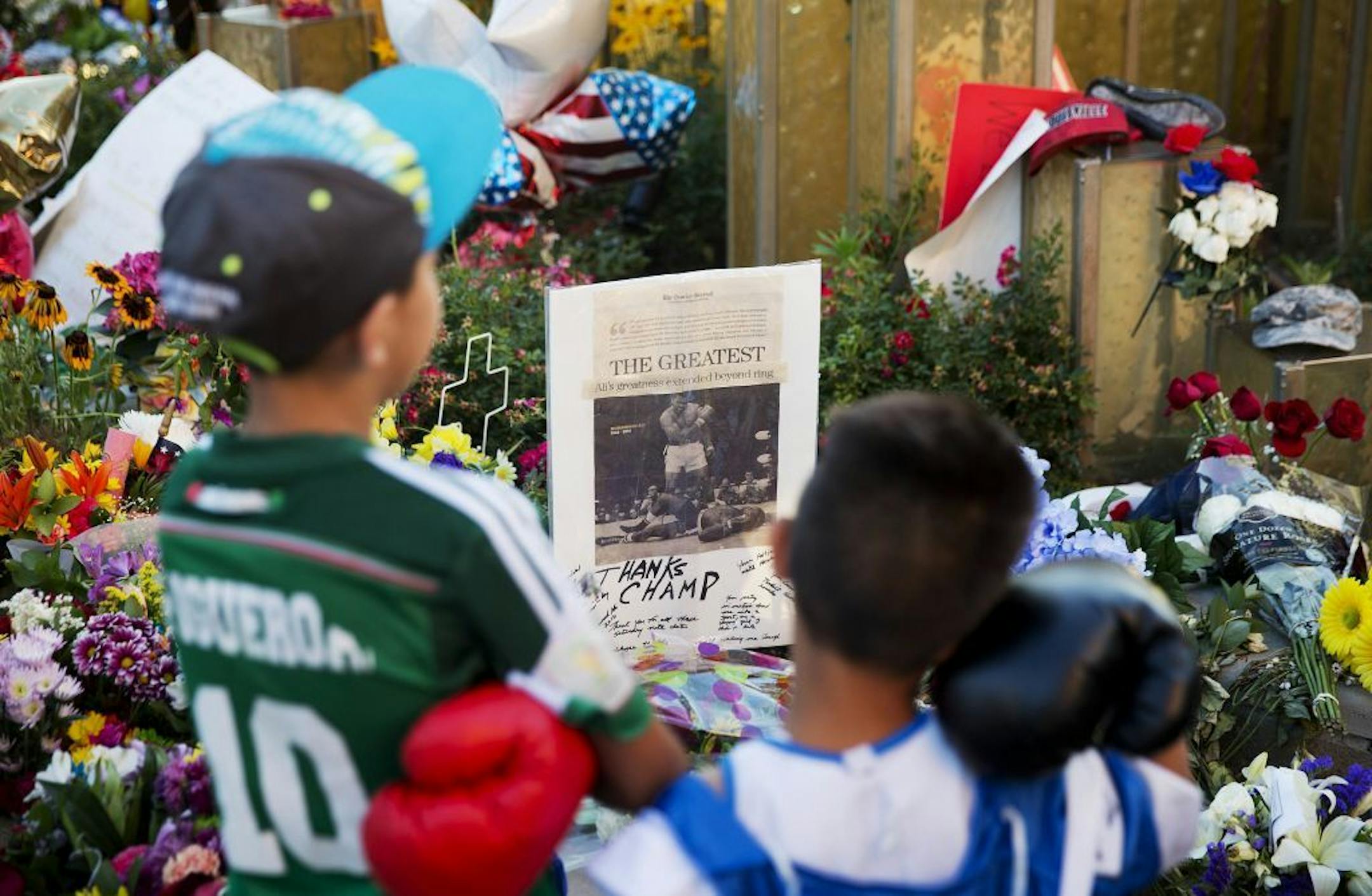 Joseph Garcia, 6, right, and Jafet Figueroa, 9, both of Louisville, look over a makeshift memorial to Muhammad Ali at the Muhammad Ali Center on Tuesday, June 7, 2016, in Louisville, Ky.