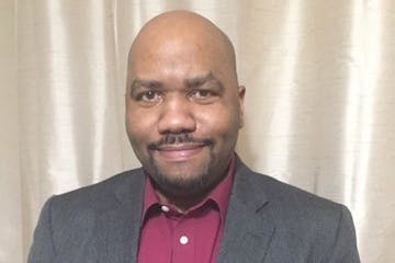 Portrait of Prof. Christopher Lehman wearing red button-down shirt and gray sportcoat.