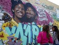 Kimberly Arellano and Abigail Tendrio pause in front of a mural put up of Kobe Bryant and his daughter along Pickford Street in Los Angeles, Monday, J