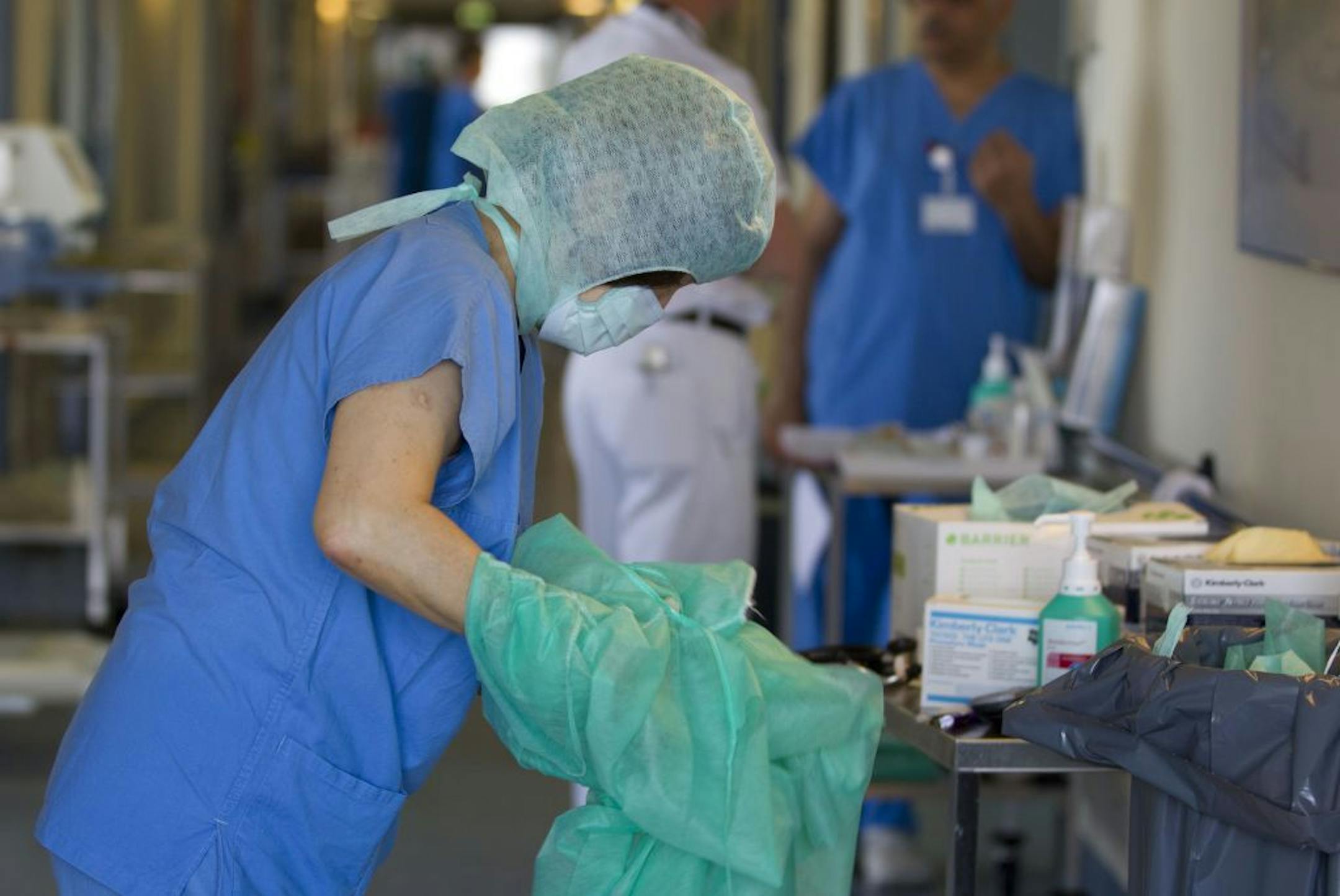 A nurse changes her protective clothing after treating an E. coli patient at the intensive care unit of Asklepios Hospital in Hamburg-Altona, Germany, Monday, June 6, 2011. Doctors at the Asklepios Hospital started to treat their E. coli patients with unorthodox therapies including antibiotics and antibodies, despite warnings by WHO and the German government.